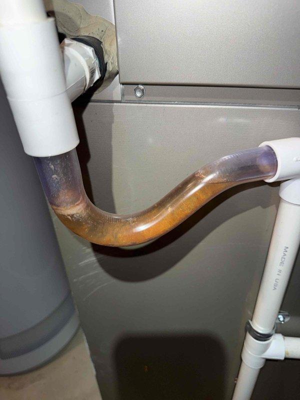 Completed comprehensive Gold Plan spring maintenance inspection on 12-year-old residential air conditioning system located at rear of property. Performed complete AC tune-up including visual inspection of outdoor condenser unit, which revealed organic growth accumulation (algae/mold) on top panel surface and fan housing area, indicating extended outdoor exposure. Inspected condenser fan assembly with protective guard grating, verified proper mounting and structural integrity of unit. Examined metal grille panels for adequate airflow circulation and checked flexible conduit connections. Assessed overall system condition appropriate for unit age, with exterior components showing normal weathering patterns. Condenser unit positioned on mulch bed against brick wall structure with adequate clearance for service access. No operational issues reported by customer prior to service call. Documented equipment condition through photographic records for maintenance history. System operational and 