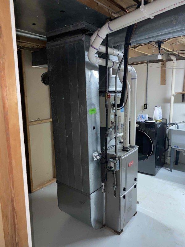Performed comprehensive assessment of 30-year-old residential HVAC system for replacement estimate. Evaluated existing air conditioning condenser unit located at rear of property and gas furnace with air handler in basement, both original equipment showing age-appropriate wear but currently operational. Documented equipment specifications, measured existing ductwork configuration including metal and PVC components, assessed electrical service and refrigerant line routing, photographed current installation for replacement planning, and provided homeowner with equipment options and system replacement recommendations for aging residential comfort system.