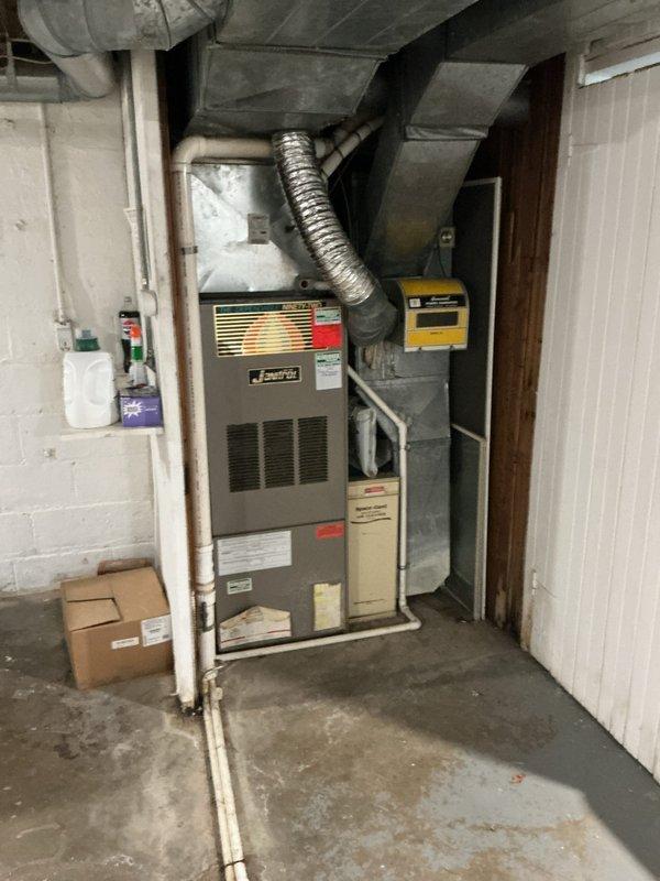 Responded to no cooling complaint on 8-year-old residential air conditioning system located in basement. Performed comprehensive leak search on refrigerant circuit and identified active refrigerant leak causing loss of cooling capacity. Conducted system evaluation and documented equipment condition with thermostat reading 73°F ambient with setpoint at 62°F, confirming inadequate cooling performance.