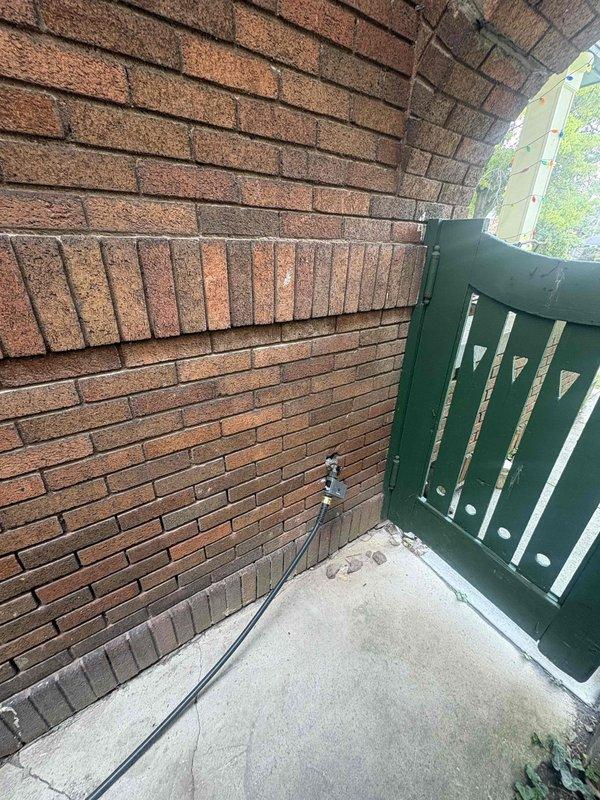 Conducted on-site assessment for electric vehicle charging station installation at residential property. Evaluated exterior electrical access point location near brick wall with existing utility connections and determined optimal routing path for dedicated charging circuit. Documented site conditions including available panel capacity, distance from main service panel to proposed charger location in exterior alcove area, and verified compliance requirements for outdoor EVSE installation.