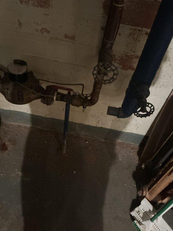 Responded to service call for damaged piping associated with forced air furnace system located in basement. Upon inspection, identified significant deterioration of insulation on supply piping, with exposed sections revealing underlying copper pipe and signs of corrosion at breach points. Documented existing plumbing infrastructure condition, including aged shut-off valves and horizontal pipe connections showing oxidation. Photographed damaged blue insulation wrapping with torn sections exposing white fibrous insulation material and compromised pipe integrity. Assessed overall mechanical room conditions and utility line configuration to determine extent of repairs needed for proper system operation and energy efficiency restoration.