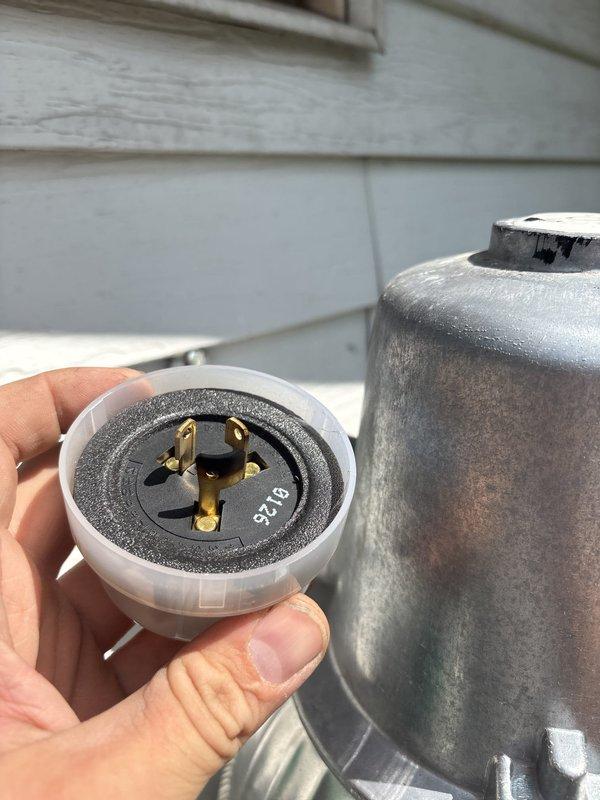 Replaced defective photocell sensor on exterior lighting fixture. Removed old photocell unit from weathered cylindrical fixture housing and installed new replacement component with proper electrical connections to restore automatic dusk-to-dawn operation.