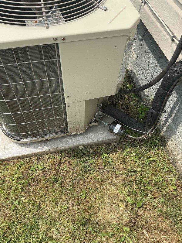 Responded to service call for central air conditioning system experiencing repeated freeze-up at outdoor condenser unit with refrigerant line icing and subsequent water leakage in basement. Upon arrival, inspected outdoor condenser unit and found system cycling improperly, causing evaporator coil to freeze and thaw repeatedly. Diagnosed restricted airflow due to dirty air filter and low refrigerant charge as primary causes of freeze-up condition. Replaced clogged air filter, checked refrigerant pressures, and identified minor refrigerant leak at service port. Recovered remaining refrigerant, repaired leak, evacuated system, and recharged to manufacturer specifications. Verified proper airflow across evaporator coil, confirmed temperature split within normal range, and tested system operation through complete cooling cycle. System now operating normally without freeze-up. Advised homeowner on importance of regular filter changes to prevent future airflow restrictions.