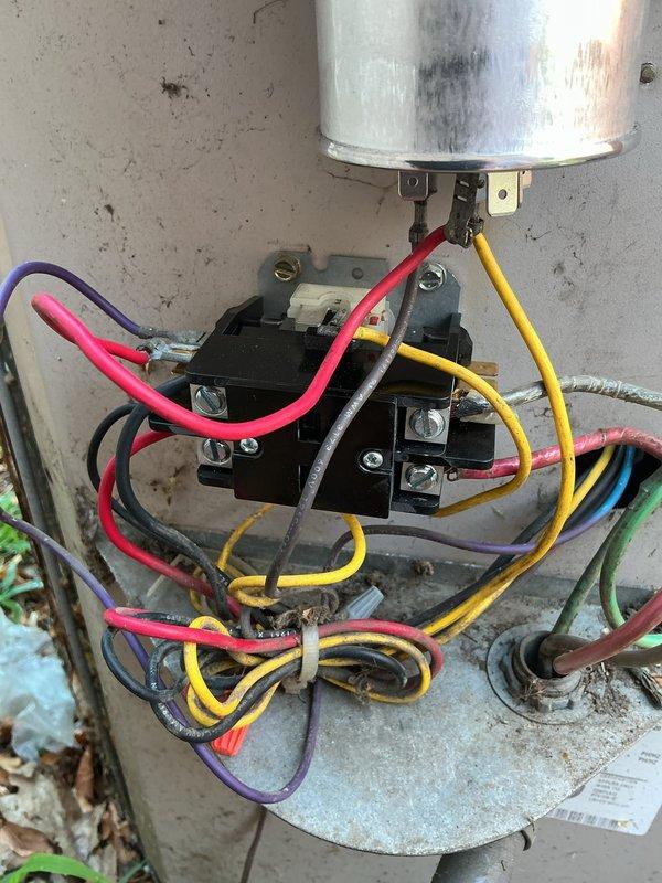 Responded to callback for non-operational first-floor heating and cooling system with outdoor unit fan failure. Upon inspection, found failed contactor with visible heat discoloration on dual run capacitor and corroded electrical connections. Replaced defective contactor, tested capacitor under load showing weak readings, and replaced dual run capacitor. Cleaned and tightened all electrical terminations, verified proper voltage and amperage across all connections. System restored to full operation with outdoor fan running and unit cycling properly.