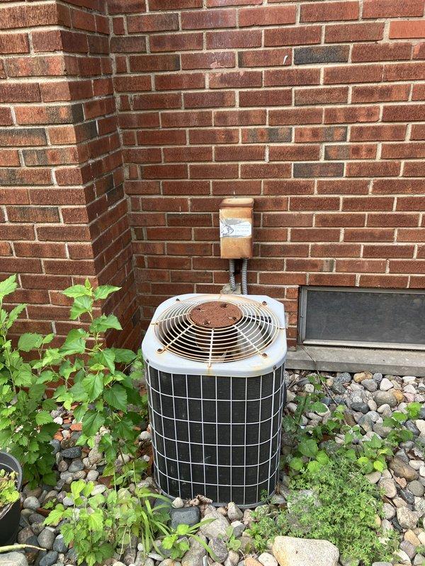Conducted comprehensive assessment of existing HVAC system for medium-sized residential property requiring full system replacement estimate. Evaluated indoor furnace unit with humidifier and air handler located in basement utility room, along with outdoor cylindrical air conditioning unit positioned against exterior brick wall. Documented current equipment configuration including natural gas furnace, ductwork connections, and aging outdoor condenser showing visible weathering and discoloration. Provided complete replacement estimate for heating and cooling system serving approximately 1500-3000 square feet of conditioned space.