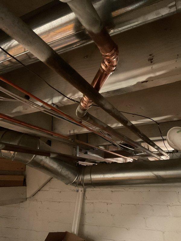 Completed installation of new copper piping system in basement mechanical area, including proper routing and securing of supply lines to existing joists with appropriate brackets and supports. Installed yellow foam insulation on designated copper pipes to prevent condensation and improve energy efficiency. All connections were soldered to code specifications, and the work was integrated with existing plumbing infrastructure while maintaining clearance from electrical panels and other building systems.
