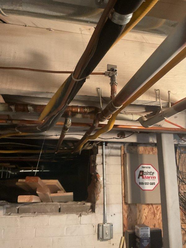 Completed installation of new copper piping system in basement mechanical area, including proper routing and securing of supply lines to existing joists with appropriate brackets and supports. Installed yellow foam insulation on designated copper pipes to prevent condensation and improve energy efficiency. All connections were soldered to code specifications, and the work was integrated with existing plumbing infrastructure while maintaining clearance from electrical panels and other building systems.