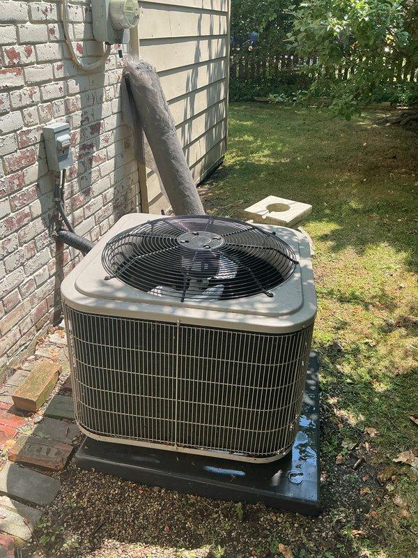 Completed comprehensive Gold AC Inspection on residential air conditioning system with outdoor condenser unit located on exterior pad and ductwork in basement area. Performed standard maintenance protocol including visual inspection of condenser unit, verified proper placement on platform pad, checked electrical disconnect and refrigerant line set condition. Inspected ventilation ductwork system and documented significant interior contamination with rust-colored staining, dark debris accumulation, and moisture damage visible within flexible metallic ducting. Noted deterioration of duct interior surfaces with brown and orange discoloration indicating corrosion and extended service period. Exterior condenser unit showing normal wear for 5+ year old equipment with metal coils visible through vertical slats and fan grill accessible. Photographed equipment conditions for record. System operational at time of inspection. Recommend ductwork cleaning and potential replacement of contaminated s