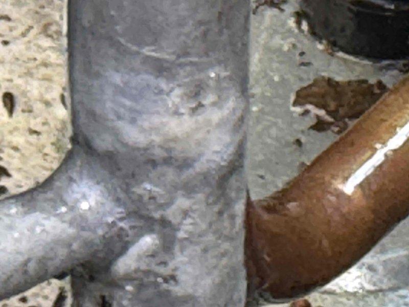 Supervisor returned to locate refrigerant leak in A/C system. Inspection revealed significant corrosion and oxidation on copper refrigerant lines with visible surface deterioration and mineral deposits at connection points. Documented corroded piping components and deteriorated fittings with photographic evidence for further assessment and repair recommendations.