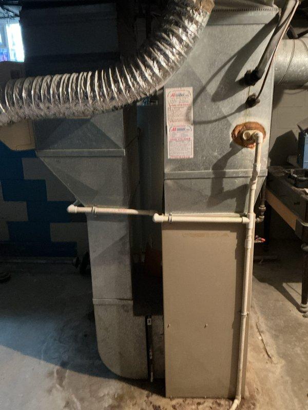 Completed estimate for replacement of existing heating and cooling system in medium-sized residential property. Assessed current basement installation consisting of aged vertical furnace with flexible ductwork, copper refrigerant lines, and PVC condensate drainage system. Recommended Lennox combination air conditioning and natural gas furnace system configured for vertical upflow/downflow application suitable for 1500-3000 square foot space. Evaluated existing ductwork connections, refrigerant line routing, and drainage infrastructure to determine compatibility with proposed replacement unit and identify any necessary modifications to accommodate new equipment installation.
