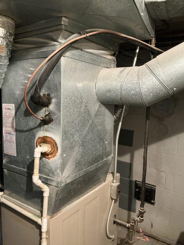 Completed estimate for replacement of existing heating and cooling system in medium-sized residential property. Assessed current basement installation consisting of aged vertical furnace with flexible ductwork, copper refrigerant lines, and PVC condensate drainage system. Recommended Lennox combination air conditioning and natural gas furnace system configured for vertical upflow/downflow application suitable for 1500-3000 square foot space. Evaluated existing ductwork connections, refrigerant line routing, and drainage infrastructure to determine compatibility with proposed replacement unit and identify any necessary modifications to accommodate new equipment installation.