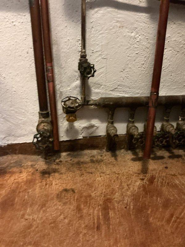 Corrected mechanical code violation on existing boiler installation by extending copper discharge piping from the backflow preventer and two pressure relief valves to terminate within 4 feet of the floor level. The original installation had inadequate discharge pipe extensions, creating a safety hazard and failing to meet code requirements for proper temperature and pressure relief valve discharge termination. Modified the existing copper piping configuration to ensure all relief valve discharge points now comply with mechanical code standards for safe operation and building inspection approval.