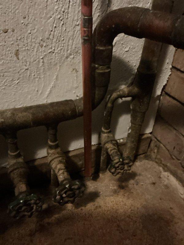 Corrected mechanical code violation on existing boiler installation by extending copper discharge piping from the backflow preventer and two pressure relief valves to terminate within 4 feet of the floor level. The original installation had inadequate discharge pipe extensions, creating a safety hazard and failing to meet code requirements for proper temperature and pressure relief valve discharge termination. Modified the existing copper piping configuration to ensure all relief valve discharge points now comply with mechanical code standards for safe operation and building inspection approval.
