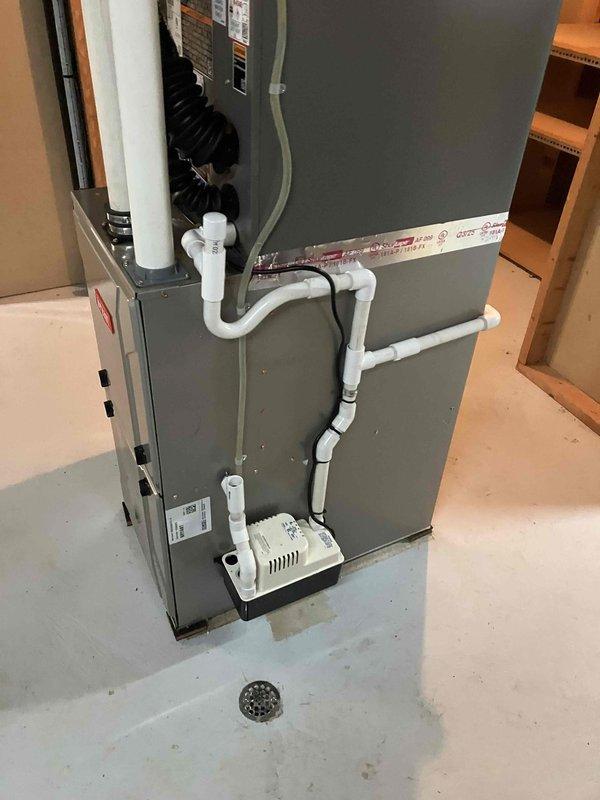 Completed full installation of 2-ton air conditioning system with matching evaporator coil in rear yard location. Installed outdoor condensing unit on concrete pad against building exterior with proper clearances, connected refrigerant lines to new indoor coil mounted on furnace unit in basement. Installed condensate pump and PVC drainage piping to handle system discharge. Reconnected electrical service to both indoor and outdoor components, verified proper voltage and amp draw. Ran and secured dryer gas line piping as requested. All mechanical, electrical, and air conditioning work performed in accordance with code requirements, permit requested for inspection.