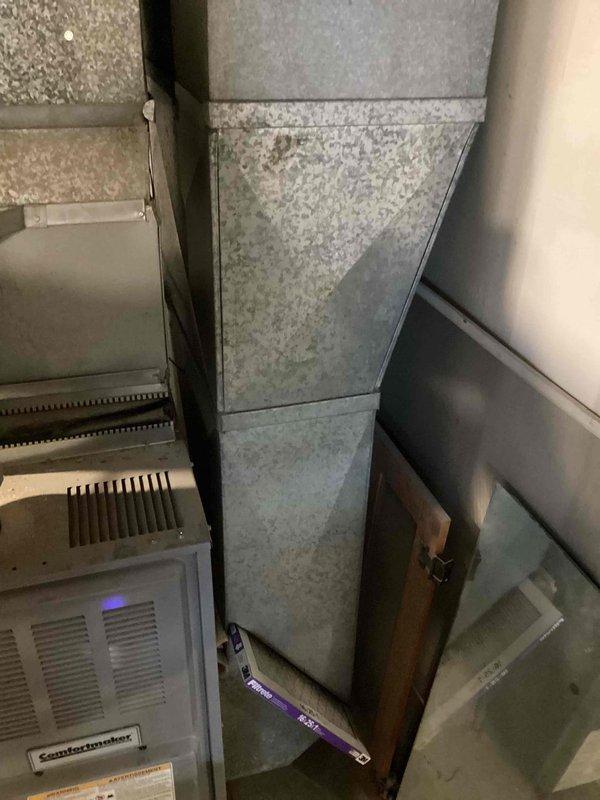 Conducted comprehensive HVAC replacement estimate for residential property where existing 20+ year old air conditioning system experienced catastrophic failure due to fire damage. Assessed outdoor condenser unit positioned on concrete pad in backyard, noting severe damage to electrical components and complete system failure. Evaluated indoor air handler and ductwork infrastructure, including existing Comfortmaker furnace unit and galvanized sheet metal distribution system in mechanical room. Documented current system configuration, refrigerant line routing, electrical connections, and ductwork layout to provide accurate replacement specifications. Recommended complete system replacement due to age of equipment, fire damage to critical components, and safety concerns with continued operation of compromised unit.