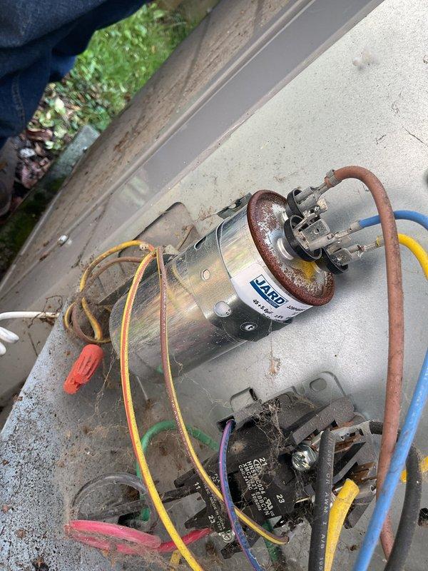 # HVAC No Cool Service Completed

Responded to a no cooling call for a 9-year-old air conditioning system affecting the entire home. Upon arrival, performed diagnostic evaluation of the outdoor condensing unit. Inspection revealed a failed dual-run capacitor preventing the compressor and condenser fan motor from operating.

Tested the existing Totaline P291A554RS capacitor (45+5 MFD) and confirmed complete failure with no measurable capacitance on either the compressor or fan terminals. Verified proper voltage supply to the contactor and confirmed 24VAC signal present at the control circuit. The contactor (HN61KC024) was functioning correctly with good contact closure when energized.

Disconnected power at the disconnect switch and discharged the failed capacitor per safety protocols. Removed the defective dual-run capacitor from its mounting bracket and installed a new replacement capacitor with matching specifications (45+5 MFD rating). Reconnected all wire terminals to their proper 