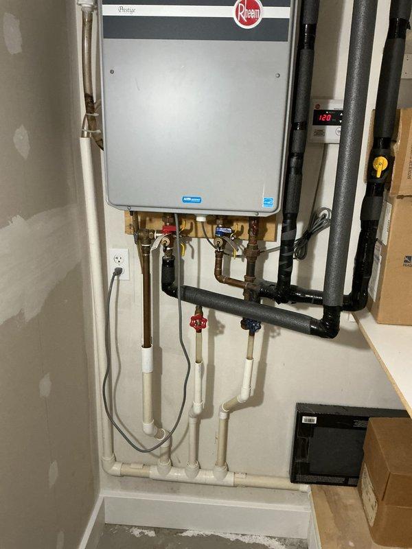 Performed comprehensive maintenance service on wall-mounted Rheem tankless water heater for new property owner. Conducted complete system flush to remove mineral buildup and sediment, inspected all plumbing connections including copper supply lines and brass fittings with isolation valves, verified proper operation of unit and all components, and confirmed system temperature output at 129°F. All components found to be in good working order with no leaks or operational issues detected.