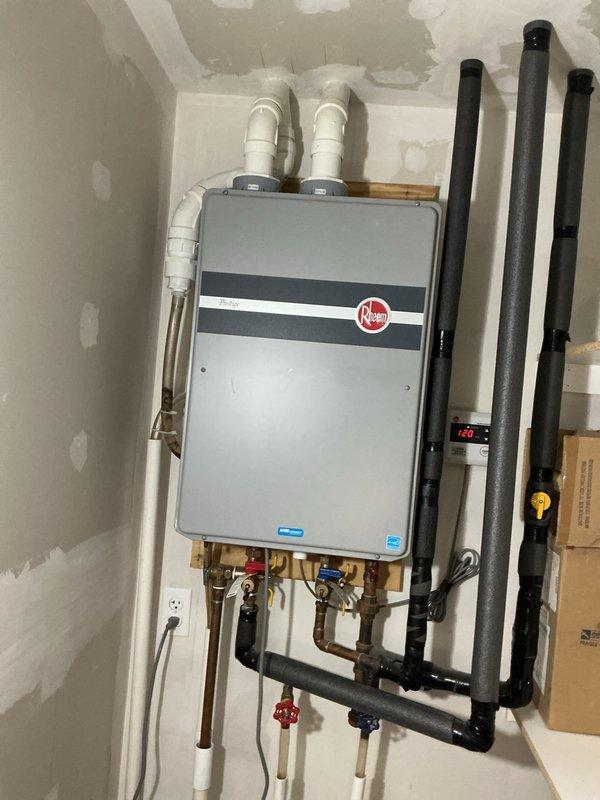 Performed comprehensive maintenance service on wall-mounted Rheem tankless water heater for new property owner. Conducted complete system flush to remove mineral buildup and sediment, inspected all plumbing connections including copper supply lines and brass fittings with isolation valves, verified proper operation of unit and all components, and confirmed system temperature output at 129°F. All components found to be in good working order with no leaks or operational issues detected.