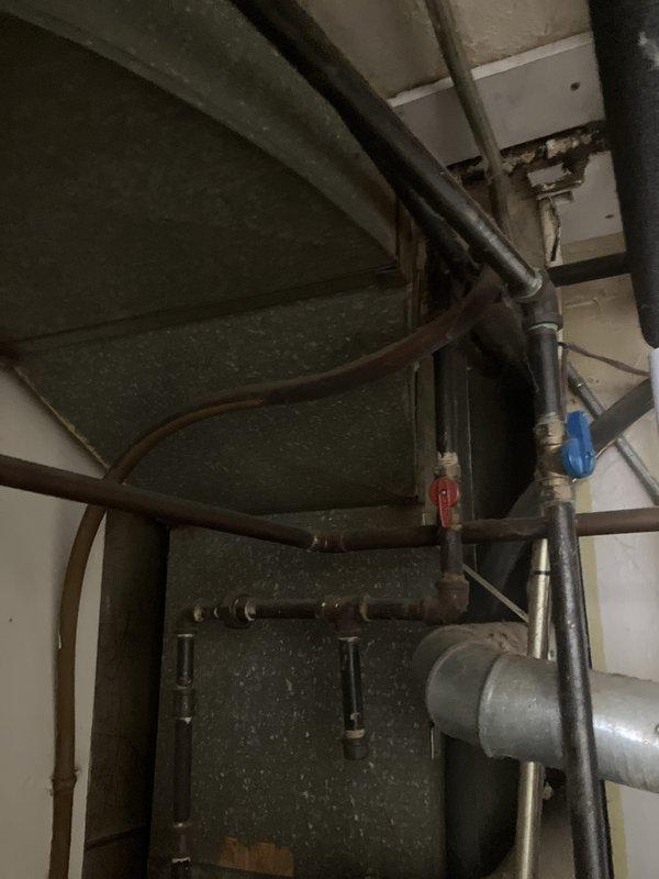 Responded to service call for non-operational air conditioning system. Upon arrival, performed comprehensive assessment of existing HVAC equipment located in basement and backyard. Evaluated aging furnace and air conditioning components, including inspection of ductwork, copper refrigerant lines, and associated piping systems with shut-off valves. Documented current system configuration showing older green metal furnace unit with visible oxidation on copper piping and flexible metallic ductwork. Provided detailed estimate for complete HVAC system replacement to address non-functional outdoor condensing unit and related equipment failure.