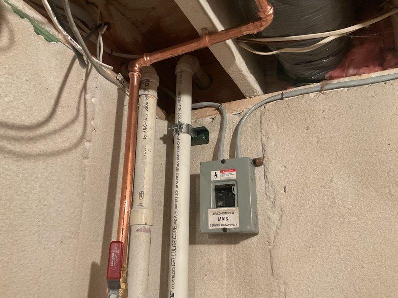 Completed plumbing repair service at residential property where customer enrolled in Gold Plan membership, receiving applicable discount on total repair cost. Inspected and serviced plumbing infrastructure in attic utility space, including copper water supply lines and white PVC drainage system mounted near HVAC electrical disconnect panel. Evaluated exterior plumbing connections associated with air conditioning condenser unit, including condensate drainage line and PVC piping with insulation wrap mounted to exterior brick wall, ensuring proper drainage function and system integration.