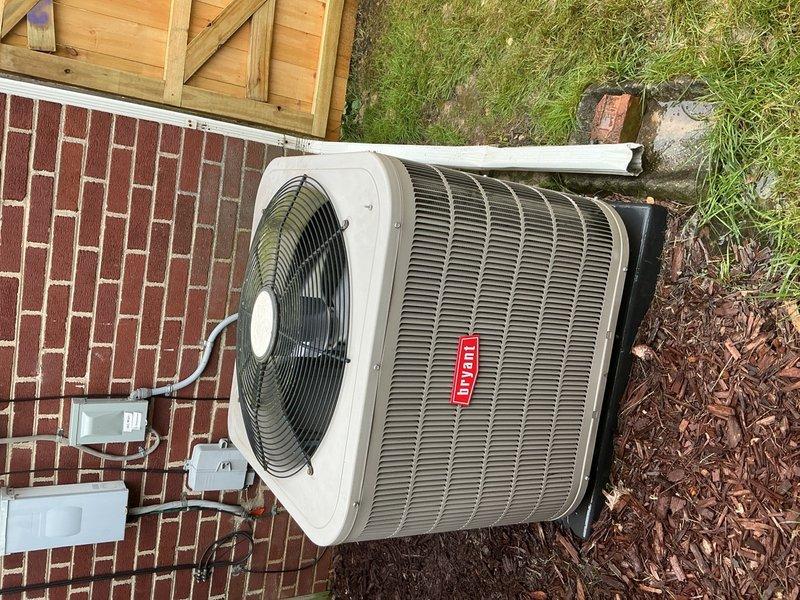 Completed Gold AC inspection on a 6-7 year old Bryant split system with air handler located in basement and condensing unit positioned on exterior concrete pad. Performed comprehensive evaluation of indoor and outdoor components, inspected refrigerant lines and electrical connections running between units, verified proper operation of condensing unit fan assembly and protective grilles, examined air handler cabinet and filtration system in basement utility area, and assessed overall system performance. All equipment found to be in working condition at time of inspection, with copper refrigerant lines, electrical conduit, and disconnect box properly secured and installed per manufacturer specifications.