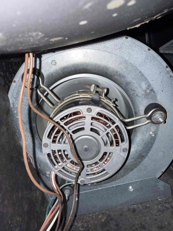 Responded to no-cooling call on 20-year-old residential air conditioning system. Upon inspection, found outdoor condensing unit completely depleted of refrigerant, indicating significant leak in aged system. Evaluated dual capacitor and electrical connections, which showed considerable weathering and dust accumulation consistent with unit age. Inspected indoor blower motor assembly, confirming operational status. Given the system's age at two decades—well beyond typical 15-year lifespan—and complete refrigerant loss, advised customer that locating and repairing leak followed by recharge would not be cost-effective compared to full system replacement. Documented equipment condition with photos showing capacitor, wiring connections, and blower assembly. Recommended replacement with modern high-efficiency unit to restore cooling and improve energy performance.