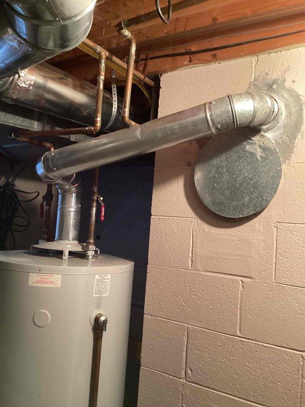 Provided estimate for replacement of 19-year-old 75-gallon natural gas hot water heater located in basement utility area. Current unit operational but nearing end of expected service life. Assessment included evaluation of existing copper supply piping, shutoff valves, venting configuration, and surrounding HVAC infrastructure to ensure proper sizing and compatibility for replacement installation.