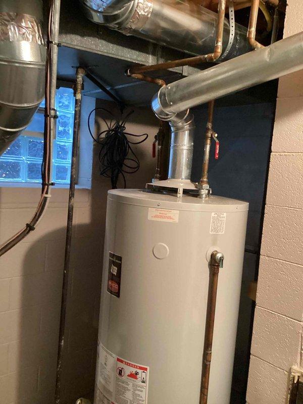 Provided estimate for replacement of 19-year-old 75-gallon natural gas hot water heater located in basement utility area. Current unit operational but nearing end of expected service life. Assessment included evaluation of existing copper supply piping, shutoff valves, venting configuration, and surrounding HVAC infrastructure to ensure proper sizing and compatibility for replacement installation.