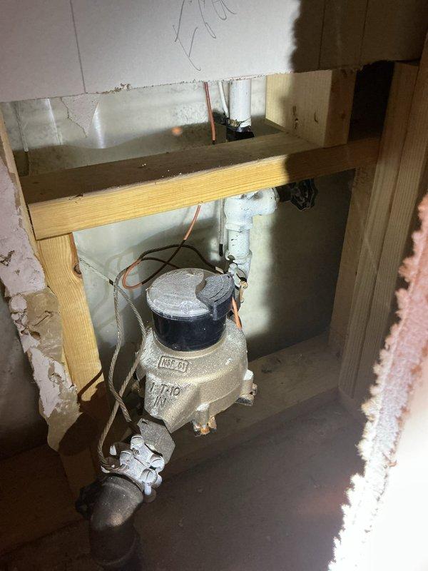Responded to service call for leaking outdoor spigot and inadequate hot water temperature in top floor bathroom shower. Accessed plumbing system through basement ceiling access panel and wall cavity to locate and inspect copper supply lines and shut-off valves. Identified source of leak at outdoor spigot connection and tightened valve assembly to stop water seepage. Inspected gas water heater valve and temperature control mechanisms to address insufficient hot water delivery to upper level fixtures. Adjusted water heater settings and verified proper gas flow through meter assembly and supply lines. Tested system operation to confirm leak repair was successful and hot water temperature increased to adequate levels for top floor bathroom shower use.