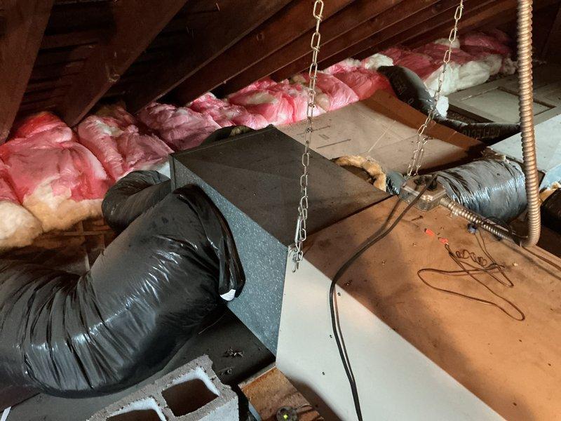 Responded to service call for non-functioning air conditioning system with no cooling throughout property. Accessed attic-mounted HVAC system through side entry and performed comprehensive assessment of existing air handler unit, flexible ductwork, and associated components. Documented current system condition including aged equipment, black flexible duct routing, insulation status, and overall installation configuration. Provided detailed replacement estimate for complete air conditioning system upgrade to restore cooling functionality.