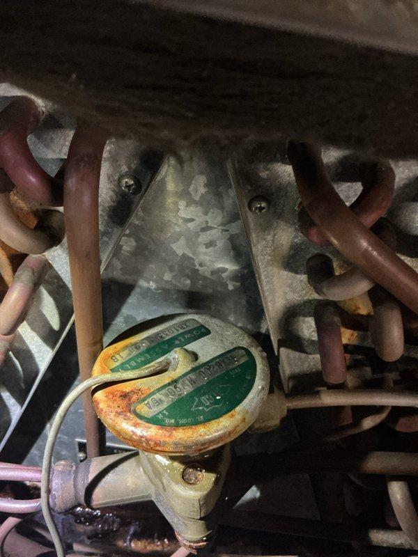 Responded to service call for reported water leak near forced air furnace located in basement. Upon inspection, discovered significant corrosion and rust on condensate drain components and associated piping connections. Evidence of prolonged moisture exposure observed on metal fittings, brackets, and drain pan assembly. Photographed deteriorated conditions including corroded gauge assembly and compromised drainage system components. Identified source of leak as failed condensate management system with blocked or damaged drain lines. Recommended immediate repair or replacement of affected components to prevent further water damage and ensure proper system operation.