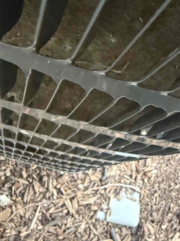Responded to service call for non-operational air conditioning system on second floor. Upon inspection, found evaporator coil with significant dirt and debris accumulation between aluminum fins, restricting airflow and reducing system efficiency. Accessed unit through service panel and documented condition of coil assembly showing brownish-green deposits and dust buildup throughout fin channels. Photographed equipment condition including exterior access panel and internal coil components for service records. Identified restricted airflow as primary cause of system malfunction requiring coil cleaning to restore proper operation.