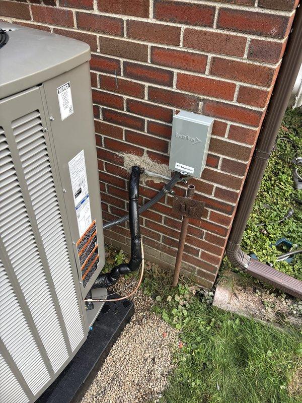 Completed full HVAC system installation including 70,000 BTU furnace with 180-degree rotation configuration and 3-ton air conditioning unit with uncased coil in rear yard location. Installed Ecobee 3 Lite thermostat, reconnected existing humidifier, and set up all electrical and mechanical connections per code requirements. Routed condensate drainage lines through exterior wall with proper PVC piping, installed black-wrapped refrigerant lines and electrical conduit to outdoor condensing unit positioned on gravel pad against brick foundation, and mounted disconnect box on exterior wall. Obtained mechanical and electrical permits, completed remeasure verification, and ensured installation qualifies for utility rebate programs under AHRI certificate 216722360.