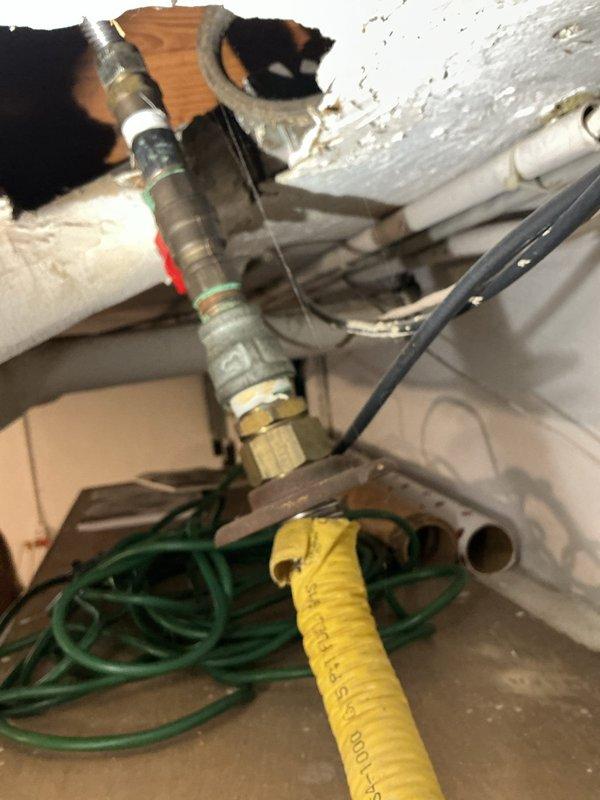 Responded to report of gas odor from oven supply line in 22+ year old residential system. Inspected gas piping running from basement to main floor kitchen and identified deteriorated flexible connector at oven connection point requiring immediate replacement for safety. Shut off gas supply at basement shutoff valve, disconnected compromised gas line section, and installed new code-compliant flexible gas connector with proper fittings and brass shutoff valve. Pressure tested all connections using approved leak detection solution to verify system integrity, restored gas service, and confirmed proper operation of oven with no detectable leaks. All work completed in accordance with local gas code requirements.