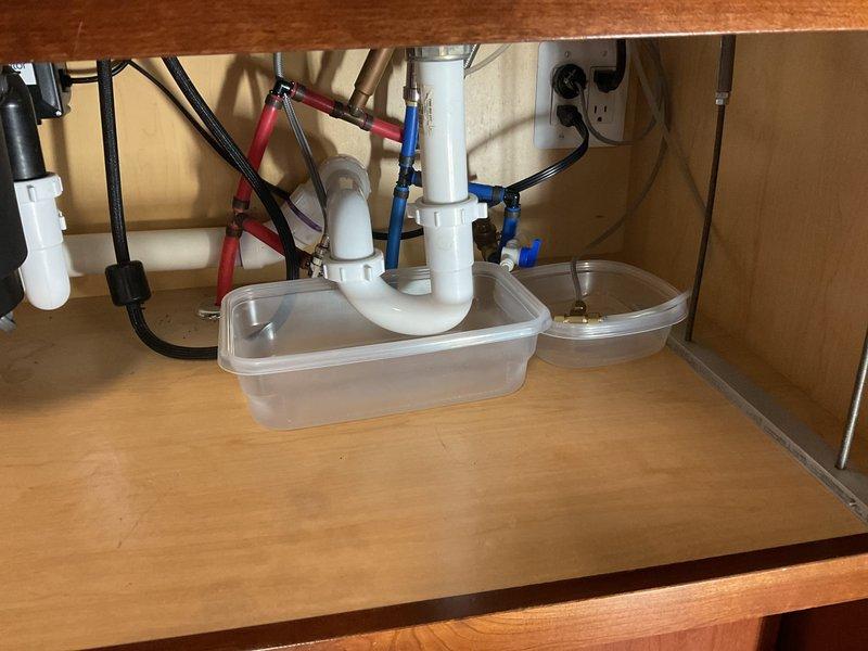 Conducted on-site evaluation of existing SUN PURE under-sink water filtration system for replacement estimate. Assessed current dual-stage filter configuration with vertical cylindrical housings and horizontal mounting assembly, documented plumbing connections and cabinet space constraints. Photographed installation area including P-trap configuration, electrical connections, and cabinet condition to provide accurate replacement system specifications and labor requirements.