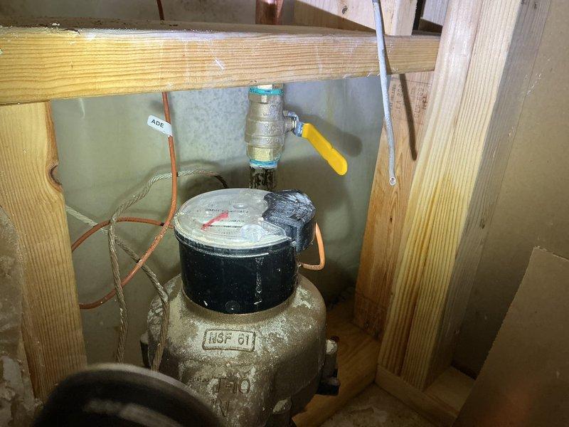 Replaced main water meter valve assembly located in basement crawl space between floor joists. Removed existing weathered galvanized valve and installed new brass ball valve with yellow handle for improved shutoff control and accessibility. Connected valve to existing copper supply lines serving the water distribution system. Additionally, replaced two frost-free exterior wall spigots on building perimeter. All new fixtures tested for proper operation and verified leak-free connections. Picked up replacement parts from Madison Plumbing supply house prior to installation.