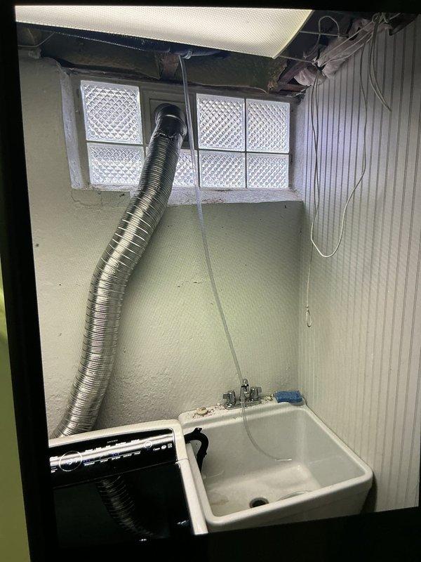 Completed installation of 2.5 ton air conditioning system with evaporator coil in right side yard location. Obtained mechanical, electrical, and AC permits, performed system reconnection, and documented installation with photos of utility room area showing workspace conditions. Noted existing humidifier drainage concern for follow-up attention.