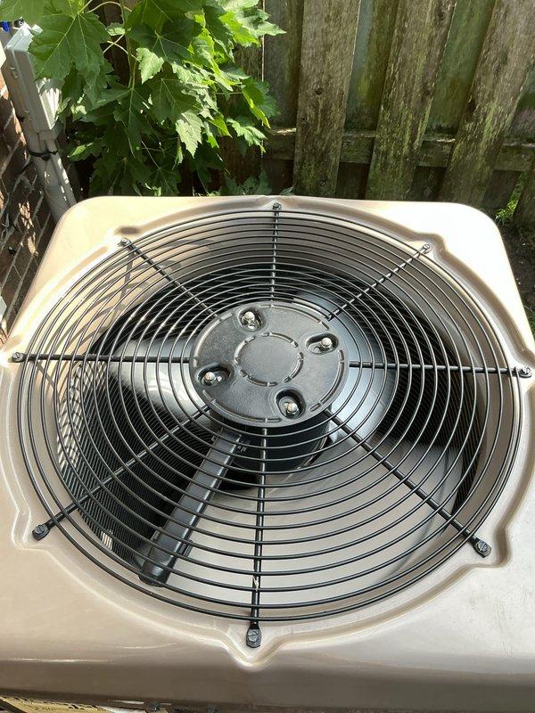 Completed Gold AC Inspection on a 2-year-old residential air conditioning system with outdoor condenser unit located in backyard and air handler in basement. Performed comprehensive visual inspection of condenser unit, verified fan operation and protective grille integrity, inspected refrigerant line connections, electrical disconnect box, and conduit routing along exterior wall. System found to be in normal operating condition with all components functioning properly at time of inspection.