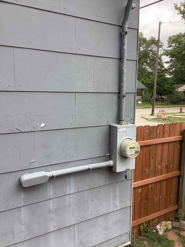 Conducted on-site assessment for heating and cooling system replacement at a small residential property (0-1500 sq.ft.). Evaluated existing natural gas furnace located in interior closet and assessed ductwork configuration, noting measurements and clearances for replacement equipment. Inspected exterior condenser location and electrical conduit routing along building exterior to determine installation requirements for new HVAC system.