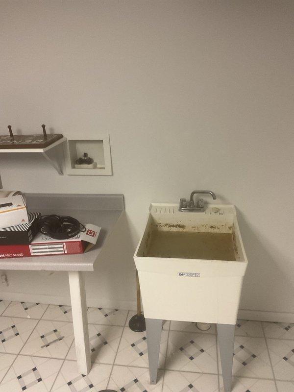 Responded to clogged utility sink in basement with complete blockage and foul odor. Upon arrival, found sink basin full of standing water with significant drainage obstruction isolated to the utility sink fixture only. Cleared drain line blockage, restored proper drainage flow, and verified system operation. Sink now draining properly with no odor present.