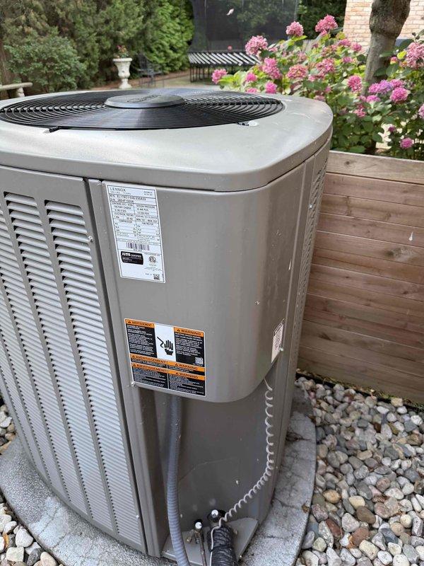 Completed comprehensive Gold AC inspection on residential property with two 2-year-old air conditioning systems. Performed thorough evaluation of outdoor condensing unit located on concrete pad with proper drainage and clearance. Conducted electrical diagnostics using digital multimeter to verify proper voltage, amperage, and capacitor function across all electrical components. Inspected wiring connections, terminals, and capacitor for signs of wear or degradation. Evaluated indoor air handler/coil equipment located in basement boiler room. Verified both units are operating within manufacturer specifications with no immediate service needs identified. All safety labels and equipment markings present and legible. System showing normal operation for equipment age with proper maintenance evident from clean installation and surrounding area. Documented equipment condition through photographic records for service history.