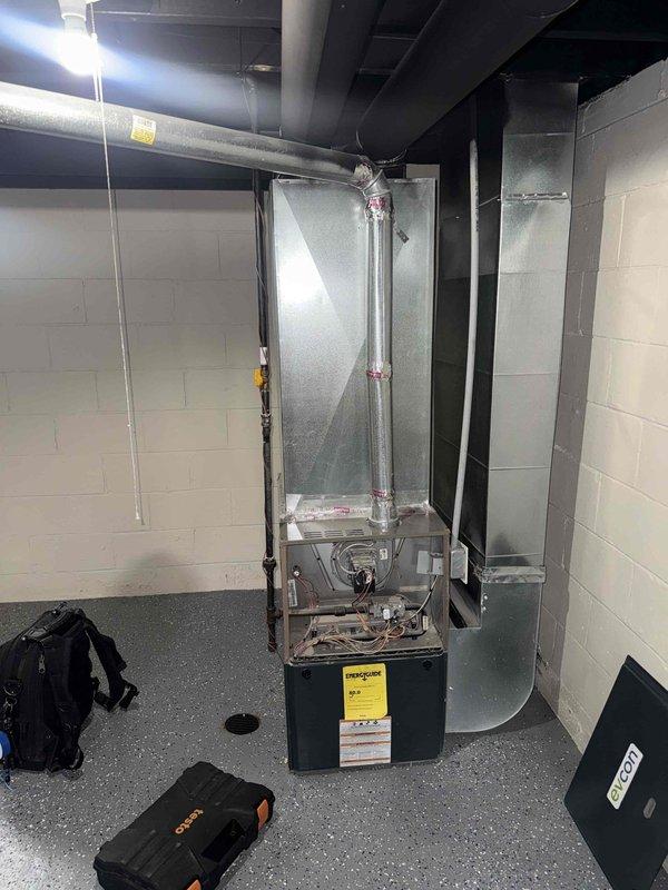 Completed system inspection on 2005 forced air furnace located in basement at homeowner's request following recent move-in. Evaluated vertical furnace unit and associated ductwork for operational status and necessary repairs. Confirmed exhaust pipe requires replacement due to age and condition concerns. Documented equipment configuration including air handler, ductwork connections, and venting system with photographic evidence for repair recommendations.
