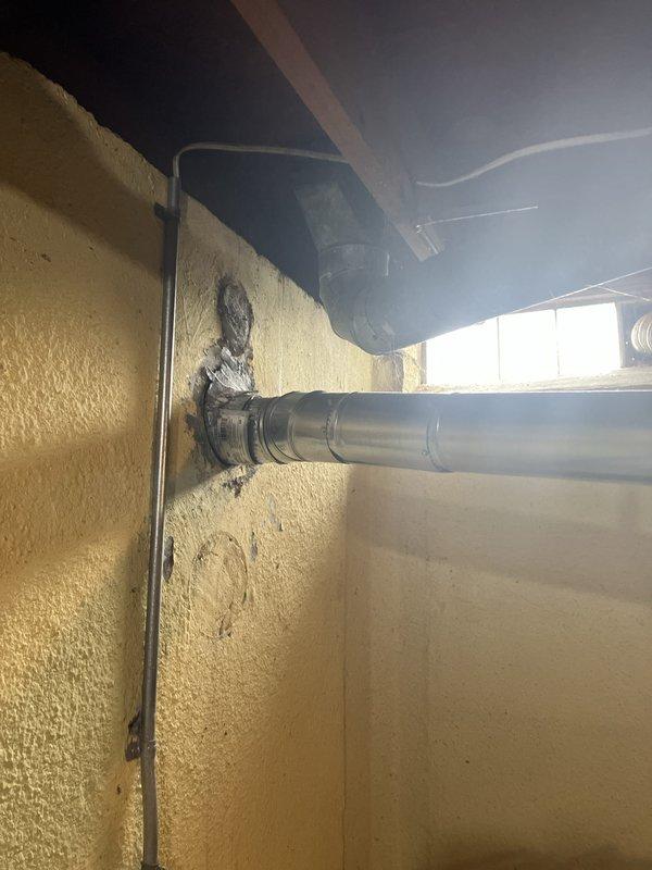 Responded to service call for water leakage from 10-year-old air handler unit located in basement. Upon inspection, identified active leak at side of unit following previous condenser repair. System operates on R22 refrigerant and showed signs of low refrigerant charge. Documented equipment condition with photographic evidence showing air handler installation, ductwork connections, and exterior condensing unit positioned against building exterior. Provided estimate for complete HVAC system replacement due to age of equipment, refrigerant type, and recurring issues with both indoor and outdoor components.