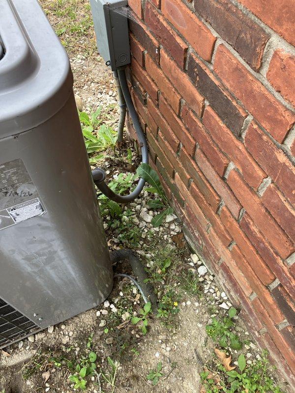 Responded to service call for water leakage from 10-year-old air handler unit located in basement. Upon inspection, identified active leak at side of unit following previous condenser repair. System operates on R22 refrigerant and showed signs of low refrigerant charge. Documented equipment condition with photographic evidence showing air handler installation, ductwork connections, and exterior condensing unit positioned against building exterior. Provided estimate for complete HVAC system replacement due to age of equipment, refrigerant type, and recurring issues with both indoor and outdoor components.