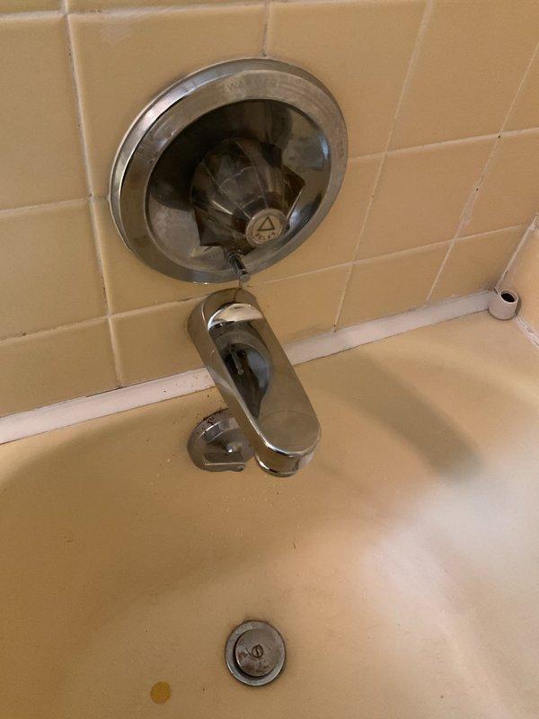 Responded to plumbing repair request and picked up necessary parts from Madison location per instructions. Inspected bathroom bathtub fixtures including chrome spout, diverter assembly, and drain components, noting age-related wear and discoloration on the tiled surround and tub basin. Evaluated under-sink plumbing configuration featuring PVC P-trap, garbage disposal unit, supply lines, and water filtration system to assess overall plumbing condition and identify any related issues requiring attention.
