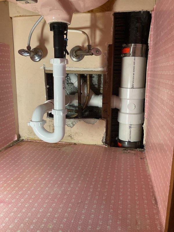 Responded to plumbing repair request and picked up necessary parts from Madison location per instructions. Inspected bathroom bathtub fixtures including chrome spout, diverter assembly, and drain components, noting age-related wear and discoloration on the tiled surround and tub basin. Evaluated under-sink plumbing configuration featuring PVC P-trap, garbage disposal unit, supply lines, and water filtration system to assess overall plumbing condition and identify any related issues requiring attention.