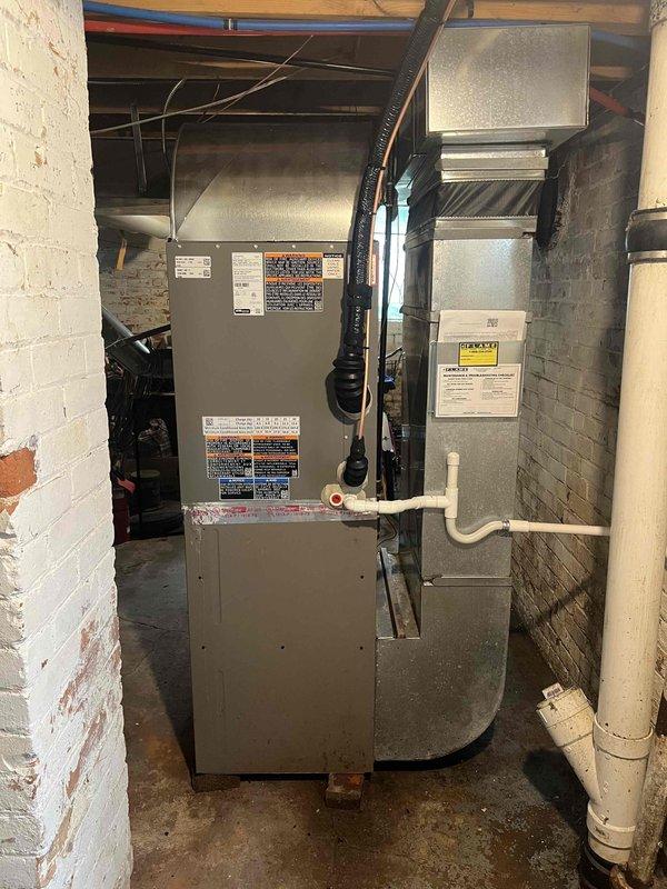 Completed installation of new air conditioning system and evaporator coil in basement mechanical room. Installed new air handler unit with proper condensate drainage using white PVC piping, connected black flexible conduit for electrical service, and integrated metal ductwork with existing HVAC infrastructure. System was properly mounted, all connections secured, and unit positioned for optimal airflow and serviceability in accordance with manufacturer specifications and local building codes.