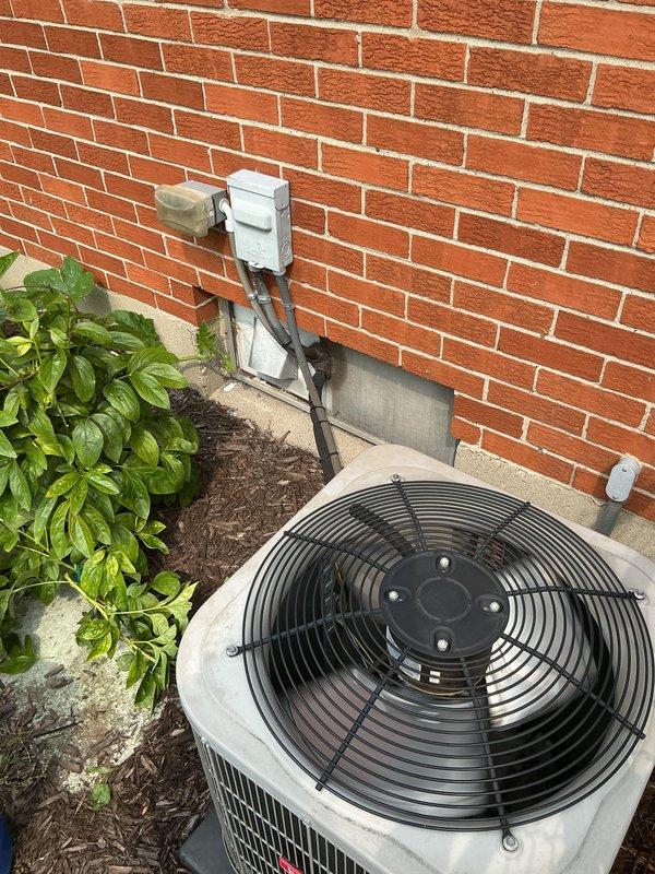 # Gold AC Inspection Completed

Performed comprehensive Gold-level preventative maintenance inspection on residential split-system air conditioning unit. Inspected outdoor condenser unit located against exterior brick wall, verifying proper clearance from landscaping and structural components. Examined electrical disconnect box, conduit connections, and power supply lines for secure mounting and proper termination. Assessed condenser fan motor operation, fan guard integrity, and refrigerant line connections at outdoor unit.

Proceeded to basement equipment location to inspect indoor components of the system. Evaluated Lennox furnace unit serving as the air handler for the cooling system. Inspected PVC condensate drain lines for proper pitch and drainage. Verified blower motor operation and examined air handler cabinet for proper sealing. Checked filter access area and documented equipment model information. Assessed ductwork connections and transitions at air handler for secure fasteni