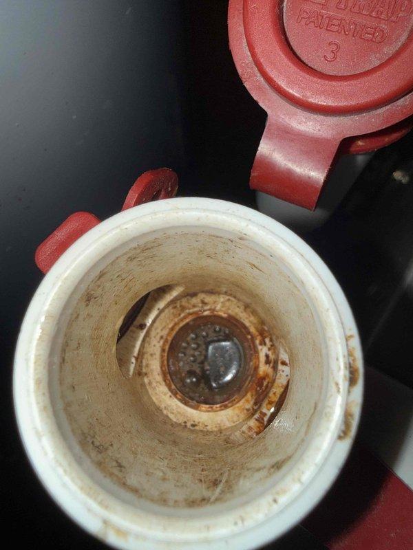 Responded to water leak complaint on 13-year-old air conditioning system located in basement. Upon inspection, found condensate drain system with significant buildup and blockage causing water to overflow onto basement floor. Cleared clogged condensate drain line and cleaned heavily stained condensate trap, which showed extensive brown residue accumulation from prolonged use. Inspected blower motor assembly and electrical connections within air handler unit to ensure proper operation. Verified condensate drainage flowing freely after clearing blockage. System tested and operating properly with no further water leakage observed.