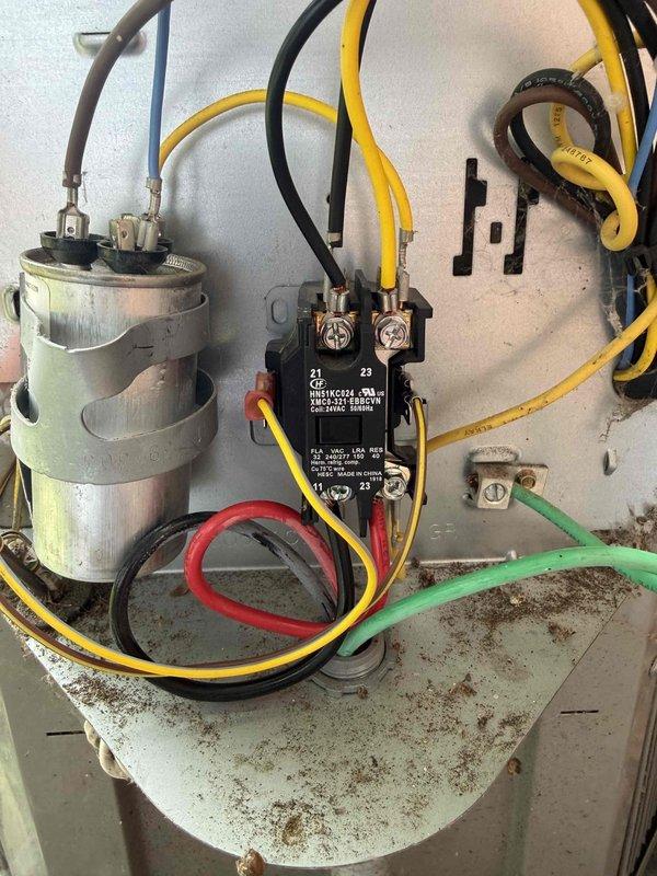 Responded to no cooling complaint on 10+ year old Bryant system located in basement. Upon inspection, found failed contactor with visible corrosion and rust on electrical assembly mounting plate, along with aged capacitor showing environmental wear. Replaced defective contactor and capacitor, verified all electrical connections, tested system operation, and confirmed unit cooling properly before departure.